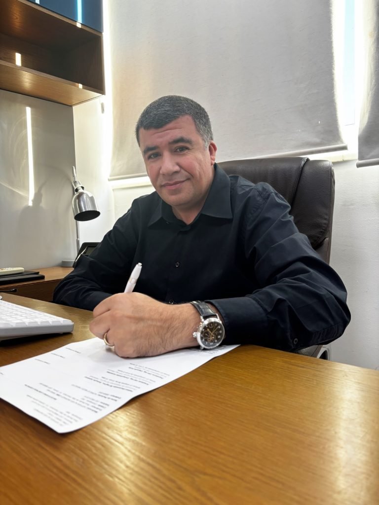 Dr. Kiffer Alves Moraes à mesa do consultório durante um atendimento