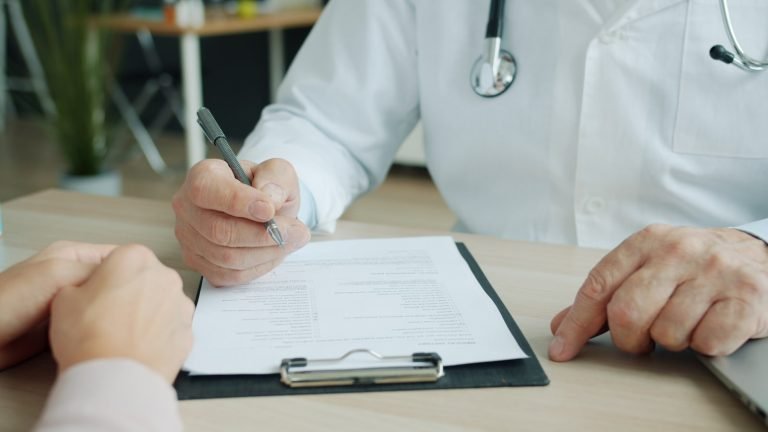 Profissional de saúde registrando a avaliação clínica do paciente em prontuário